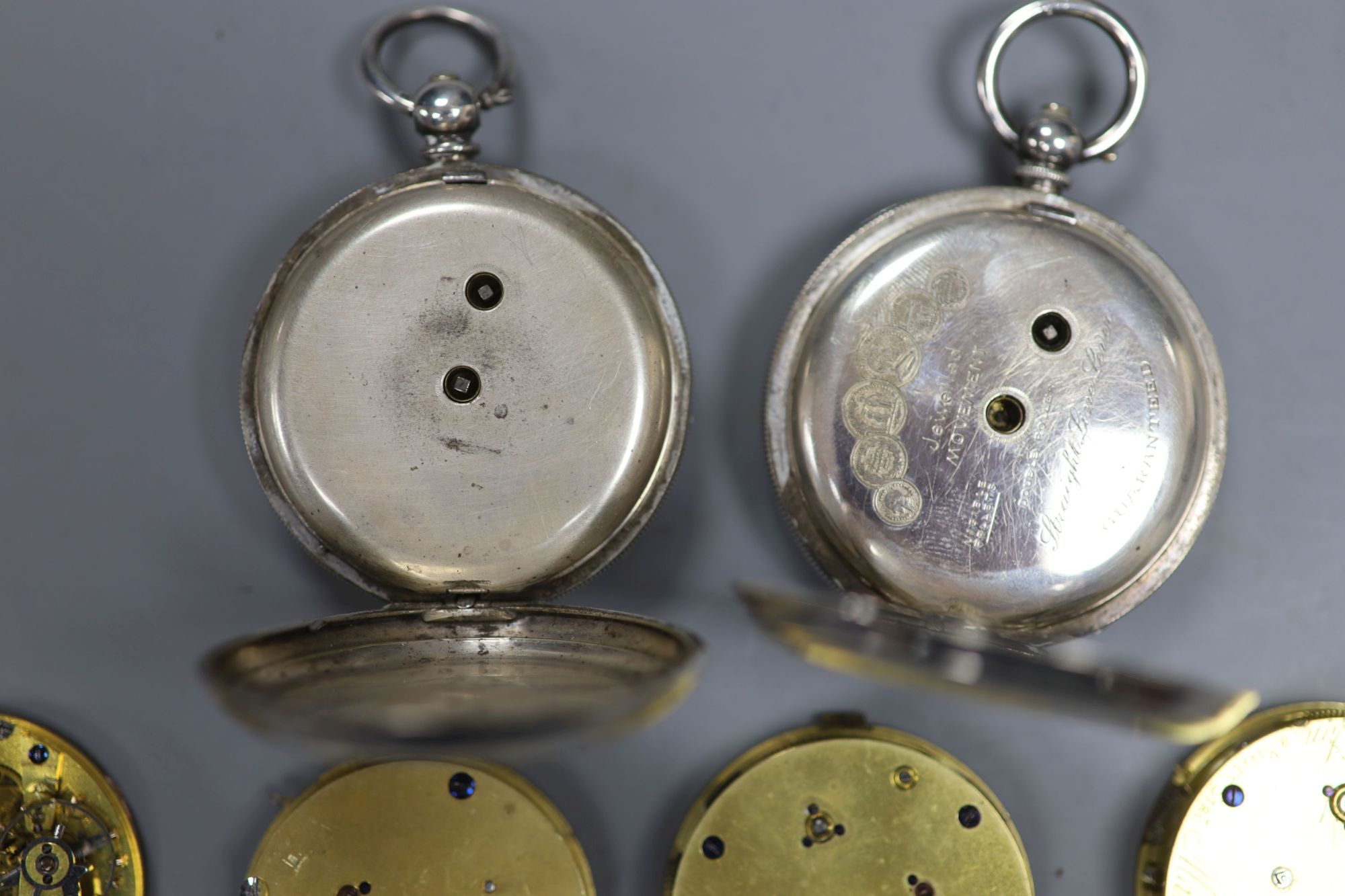 Two early 20th century silver or white metal pocket watches and four assorted pocket watch movements.